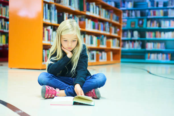 istock Child girl in library 859397010