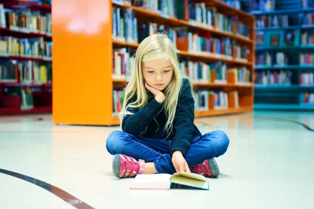 istock Child girl in library 859397026