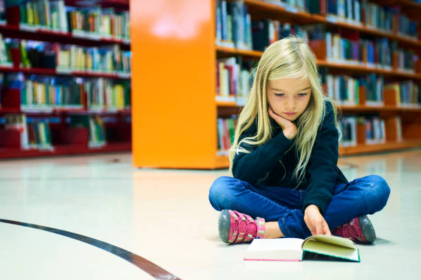 istock Child girl in library 859397036