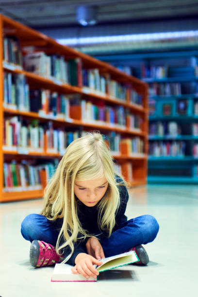 istock Child girl in library 859397040