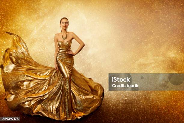 Golden Fashion Model Elegant Woman Flying Gold Dress Waving Sparkling Gown Fabric Stock Photo - Download Image Now