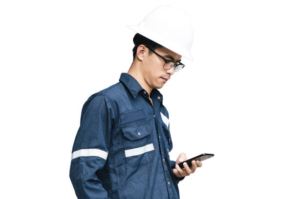 Asian man,Engineer or Technician in white helmet, glasses and blue working shirt suit using smart phone, isolated on white, mechanic and Oil and Gas industrial concept with clipping path.