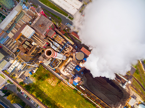 Aerial view to smoking chimmney from lignite power plant. Air pollution and climate change theme. Heavy industry from above.