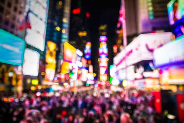Times Square NYC Blur Defocused blur of Times Square in New York City, midtown Manhattan at night with lights and people. times square stock pictures, royalty-free photos & images