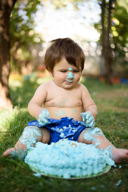 istock Baby playing with a cake during cake smash birthday party 859410392
