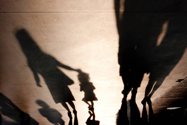 Blurry shadows of mother with a child walking stock photo