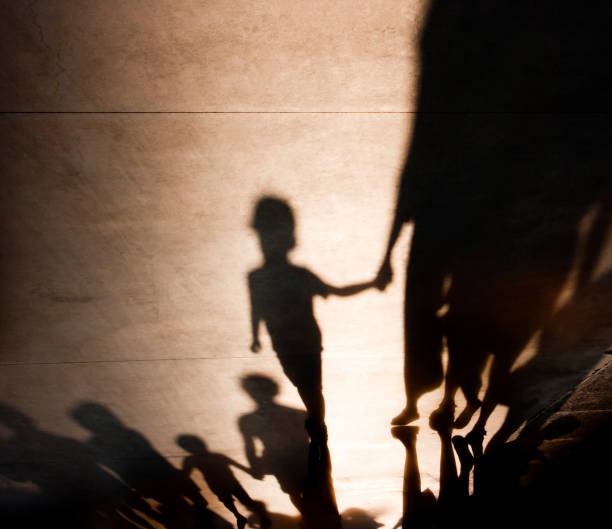 Blurry shadows of families with kids walking