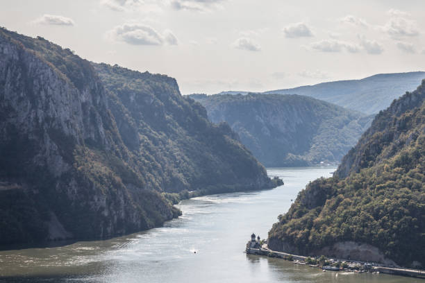 monastero di mraconia, in romania, preso dalla parte serba del danubio nelle porte di ferro (portile din fier). il monastero, uno dei simboli della chiesa ortodossa rumena, è uno dei punti di riferimento delle gole del danubio, al confine con bertween ser - danube river serbia ravine romania foto e immagini stock