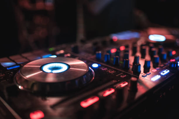 istock Hands of woman DJ tweak various track controls on dj's deck at night club 859414578