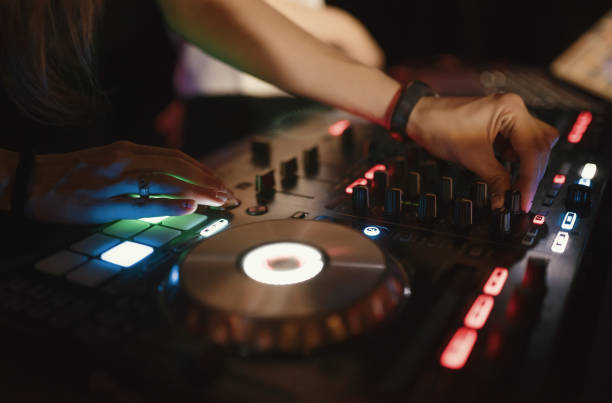istock Hands of woman DJ tweak various track controls on dj's deck at night club 859417072