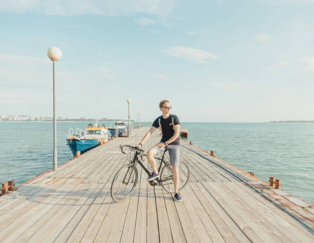 istock Man standing with bicycle on the pier. 859425746