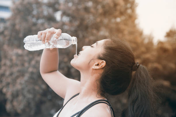 istock Sporty Asian woman drinking water. 859431220