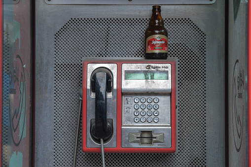 Beer bottle left by a drunk person on a phone booth of a payphone in the capital city of Serbia, Belgrade