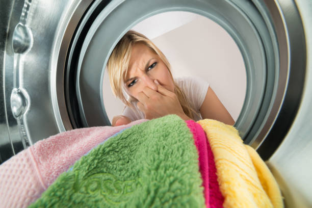 istock Woman Inserting Stinking Clothes In Washing Machine 859435072