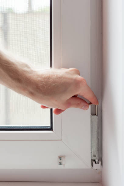 istock Handyman repairs plastic window with a hexagon. Workman adjusts the operation of the plastic window 859435612