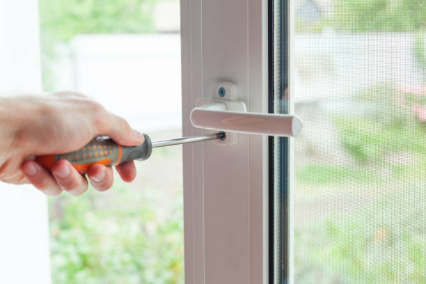 istock Handyman repairs plastic window with screwdriver. Workman adjusts the operation of the plastic window 859436202