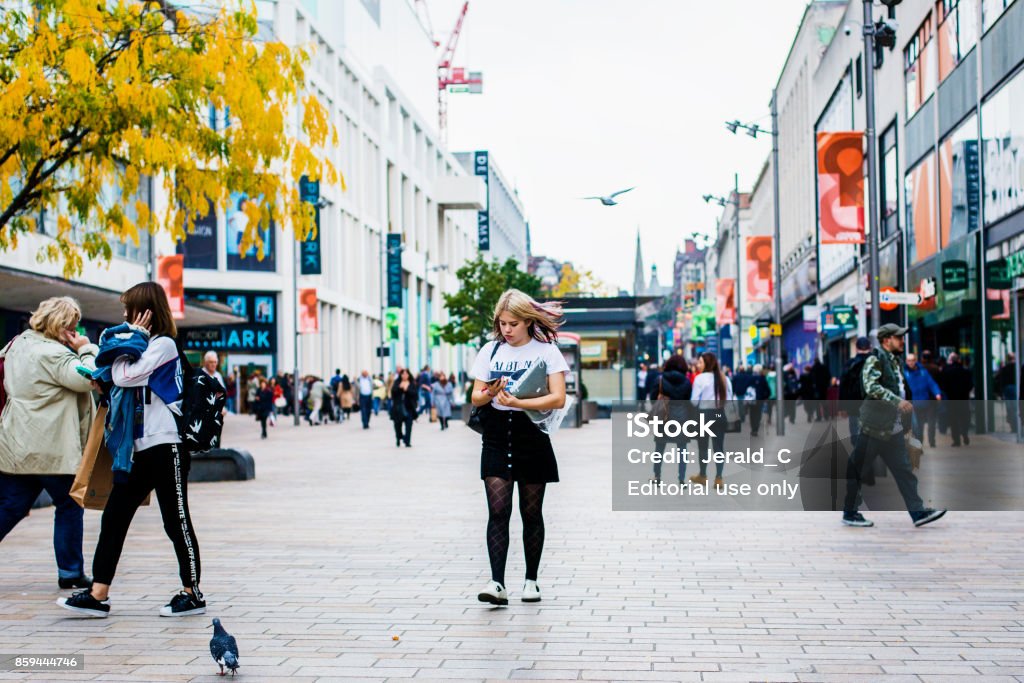 Eine Frau schaut auf ihr Mobiltelefon, wenn auf der Straße - Lizenzfrei Sheffield Stock-Foto