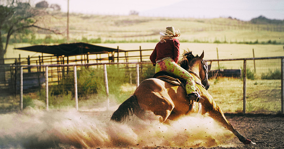 Woman Barrel racing at rodeo.