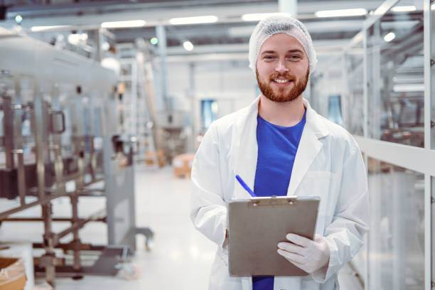 istock Young Handsome Smiling Scientist With Clipboard Posing in Factory 859455684