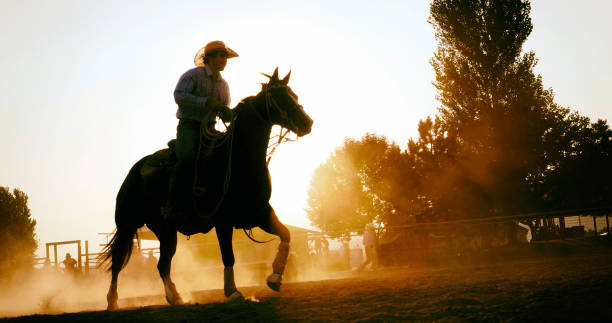 istock Cowboy Riding Horse at Sunset 859456282