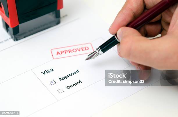 Visa And Approved Stamp On A Document Form Stock Photo - Download Image Now - Passport Stamp, Emigration and Immigration, Application Form