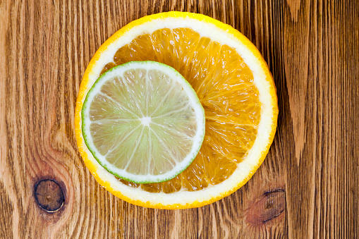 cut slices of orange and lime, lying next to each other and photographed close-up. Small depth of field
