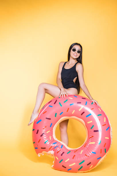 woman in swimsuit with doughnut pool float