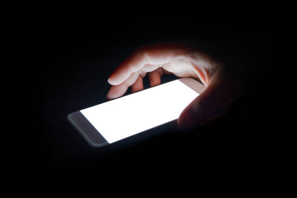 istock white light from the smartphone reflect your hand at night in the dark.blank screen for text and design 859479198