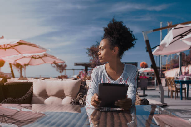 istock Afro girl in cafe with digital tablet looking aside 859481828