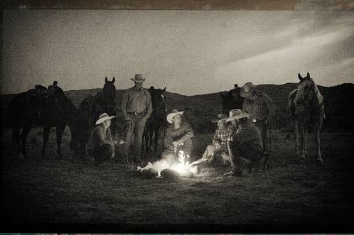 Cowboys and Cowgirls outdoors around the campfire in the west.