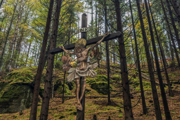 istock Jesus on crucifix in forest in national park 859485438