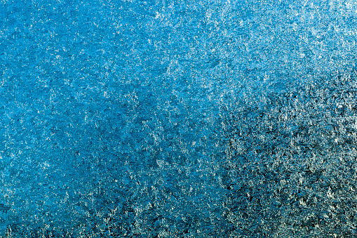 photo of a frost on the car's glass in the winter season. Rubbish, mud and other are visible on the glass. Small depth of field