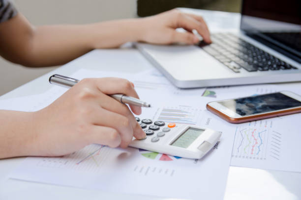 istock close up woman using calculator and laptop on paper graph data with doing finance at office. 859490390