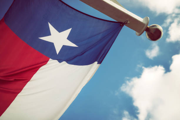 bandera del estado de texas contra el cielo azul y nubes blancas - lone star symbol fotografías e imágenes de stock