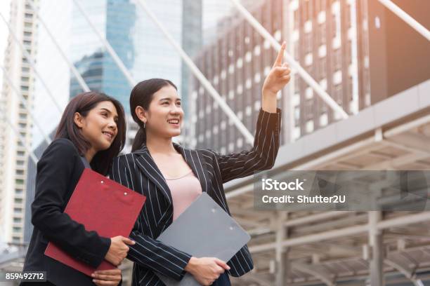 Two Young Beautiful Business Women Pointing And Smiling With Outdoor Background Business And Beauty Concept Meeting And Greeting Concept Stock Photo - Download Image Now