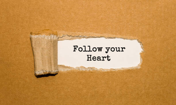 istock The text Follow your Heart appearing behind torn brown paper 859494536