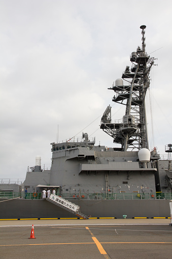 Color image of an automated machine gun on the deck of a military ship, at sea.