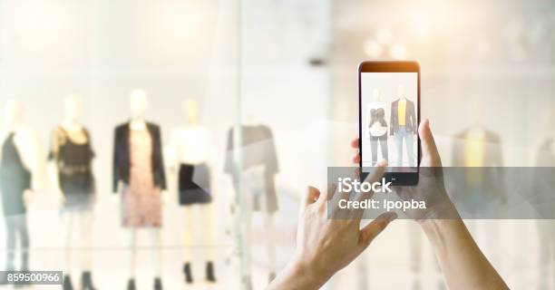 スマート フォンの携帯電話を使用して手とオンラインのコンセプトをショッピング衣料品店のディスプレイ表示で写真を撮る - 小売りのストックフォトや画像を多数ご用意