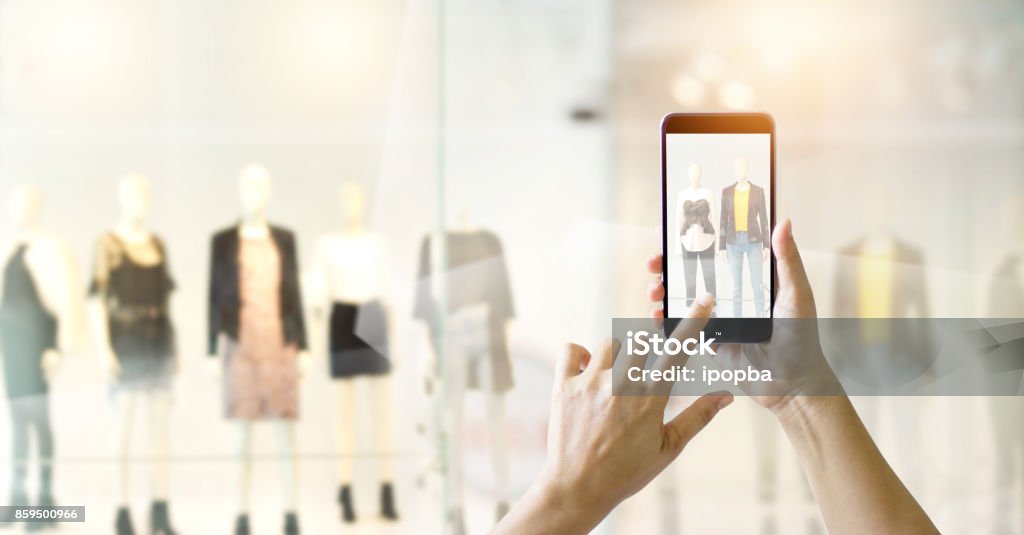 Hands using mobile smart phone and take a photo in display view of a clothing store, shopping online concept Technology Stock Photo