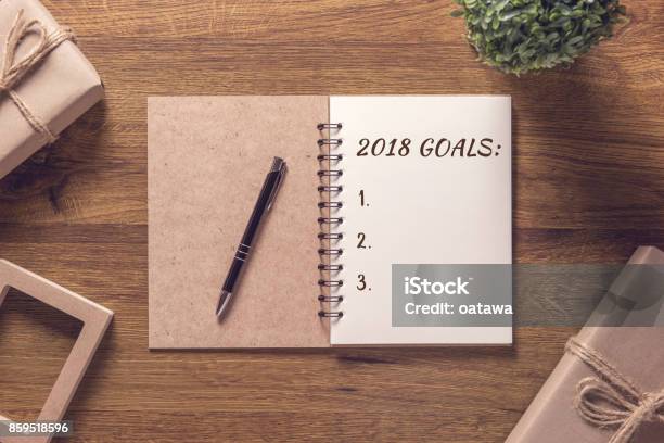 2018 Goals List In Notebook With Gift Box New Year On Wooden Table Background Stock Photo - Download Image Now