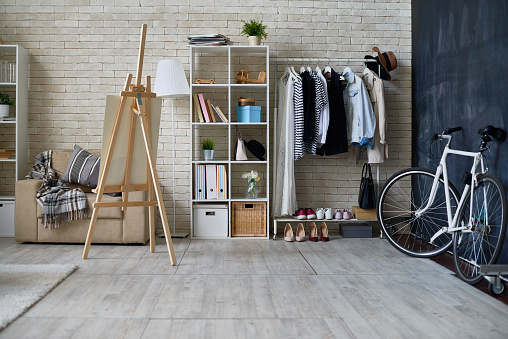 Background image of empty studio apartment with bicycle next to chalkboard wall and easel, copy space