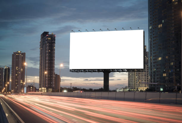 Blank billboard on the highway Blank billboard on the highway during the twilight with city background with clipping path on screen.- can be used for display your products or promotional commercial sign stock pictures, royalty-free photos & images