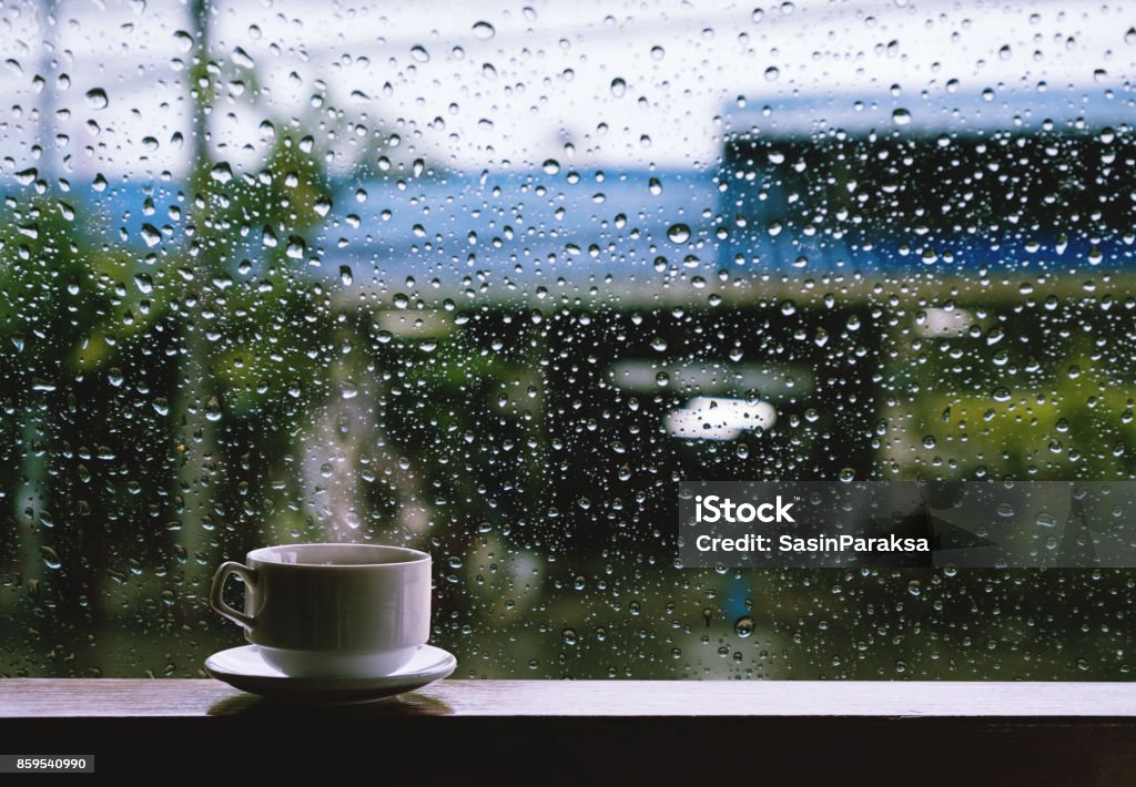 Cup of Hot Drinks on wooden table in rainy day Rain Stock Photo