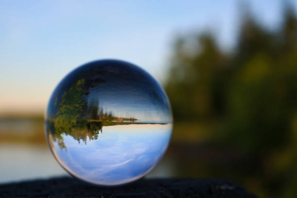 Scenic lake reflecting through a lens ball Summer lakeshore scene displayed through a transparnt glass ball in Cold Lake, Alberta looking in mirror stock pictures, royalty-free photos & images