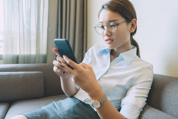 istock side view of woman sitting on sofa using smartphone 859553692