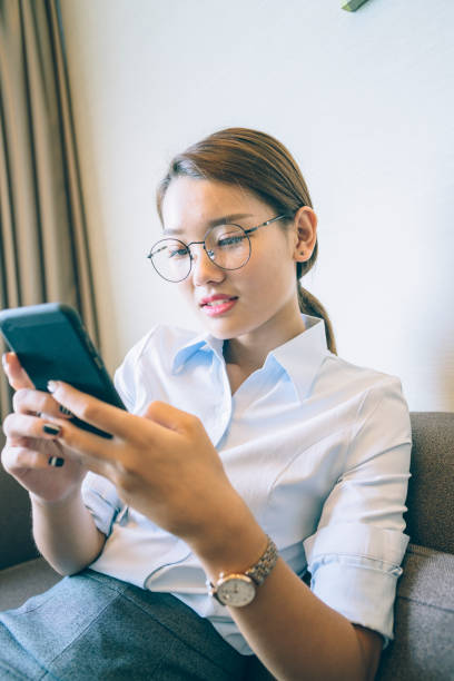 istock side view of woman sitting on sofa using smartphone 859553816