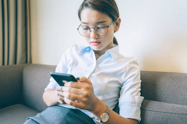 istock side view of woman sitting on sofa using smartphone 859553922
