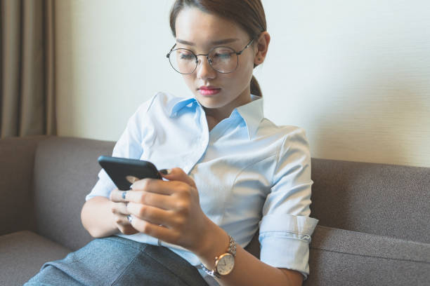 istock side view of woman sitting on sofa using smartphone 859554008