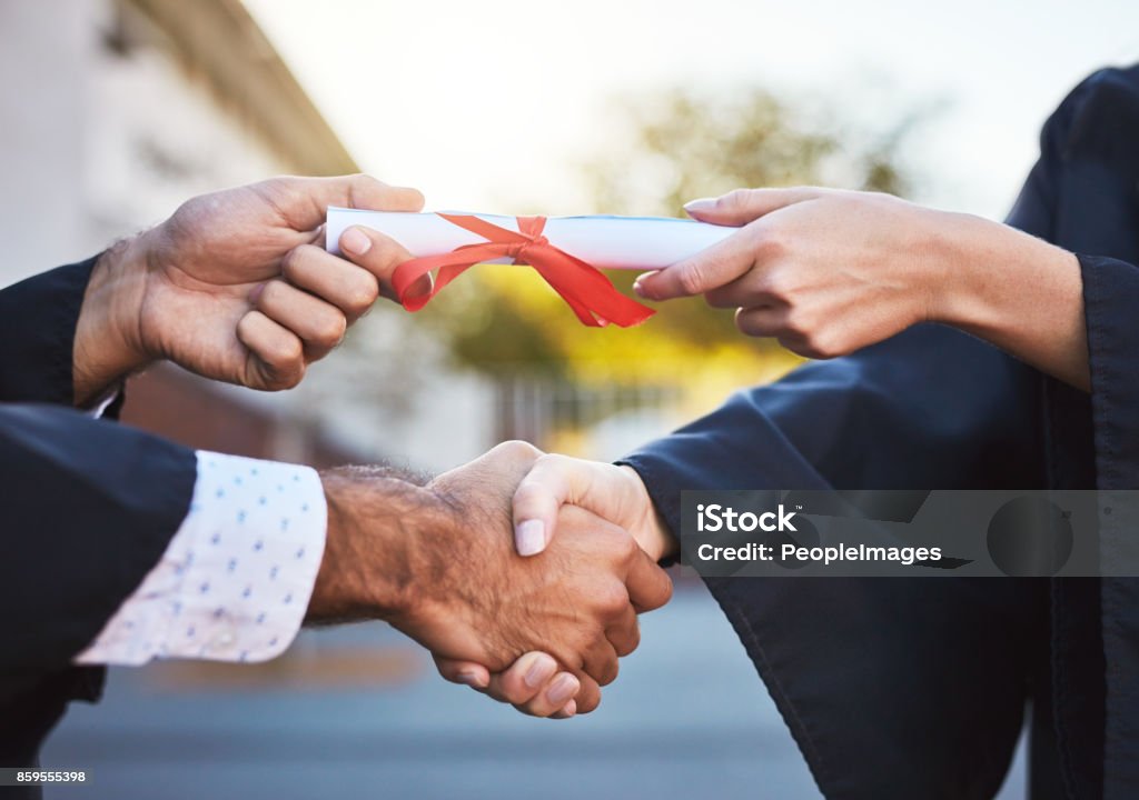 Certified success Cropped shot of students on graduation day Handshake Stock Photo