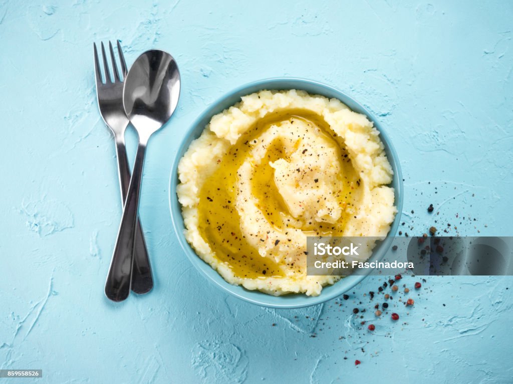 Mashed potatoes on blue concrete background Mashed potatoes with peppers and olive oil in blue bowl on blue concrete background. Top view or flat lay. Copy space. Mashed Potatoes Stock Photo